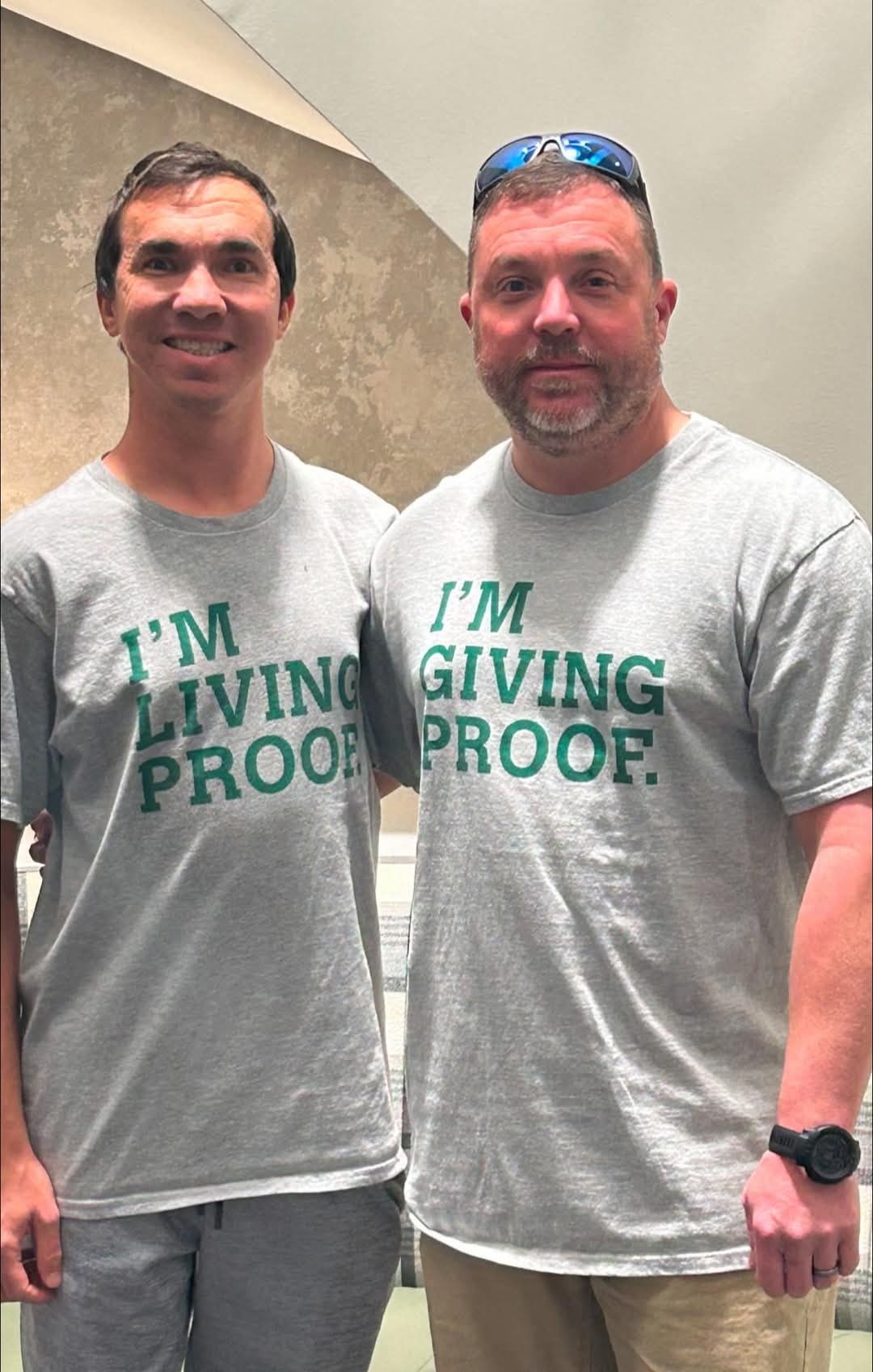 Matthew Bohl (left) and Ron Bohl stand with their "Living Proof" and "Giving Proof" tee shirts following a paired donor kidney transplant.